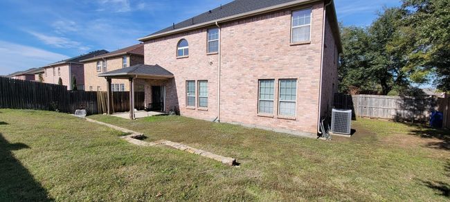 Back of property with a patio area, brick siding, and a fenced backyard | Image 21