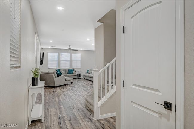 Corridor with light wood-style floors, recessed lighting, baseboards, and stairway | Image 7