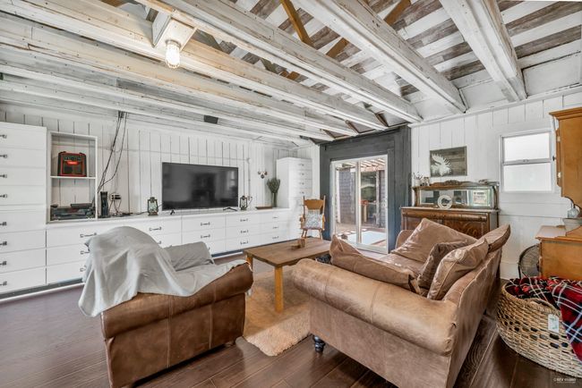 Living area featuring wood walls, beam ceiling, and dark wood-style flooring | Image 20