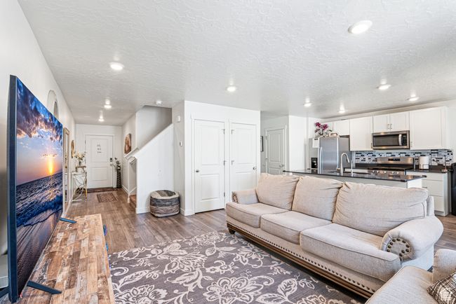 Living room with light wood-type flooring, recessed lighting, baseboards, and a textured ceiling | Image 6