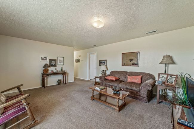 Carpeted living area featuring visible vents and a textured ceiling | Image 9