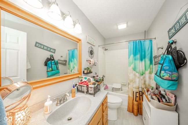 full bathroom featuring vanity, shower / bathtub combination with curtain, and a textured ceiling | Image 28