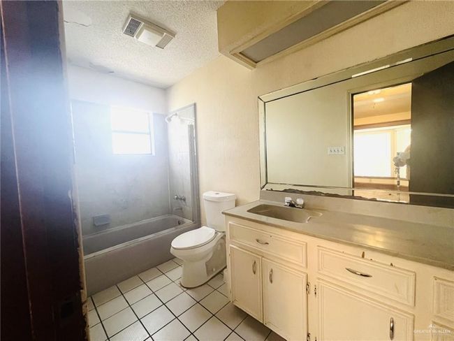 Full bathroom with shower / bathing tub combination, a textured ceiling, toilet, tile patterned flooring, and vanity | Image 12