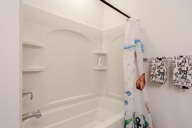 Functional and clean tub/shower combo with built-in shelving—perfect for daily routines. | Image 29