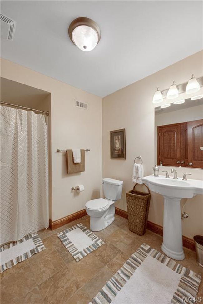 Bathroom with toilet and a shower with curtain | Image 58