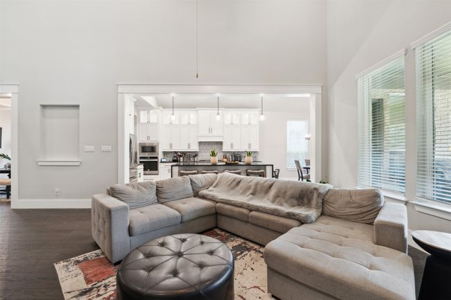 Living area featuring a high ceiling and dark wood-style flooring | Image 10