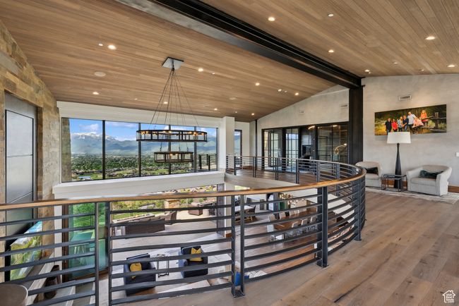 Hallway featuring wooden ceiling, hardwood / wood-style flooring, recessed lighting, an upstairs landing, and a chandelier | Image 100