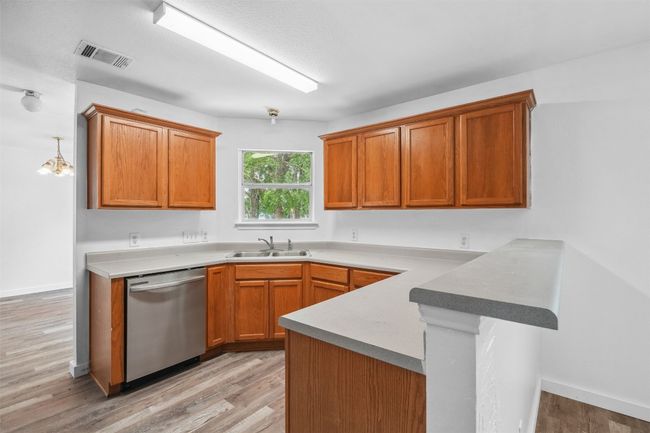 Kitchen with a peninsula, light wood-style floors, a sink, and dishwasher | Image 14