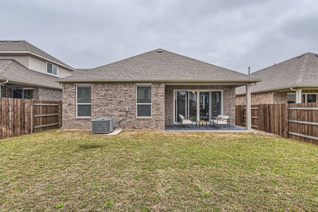 Back of property featuring roof with shingles, a fenced backyard, cooling unit, brick siding, and a patio area | Image 24