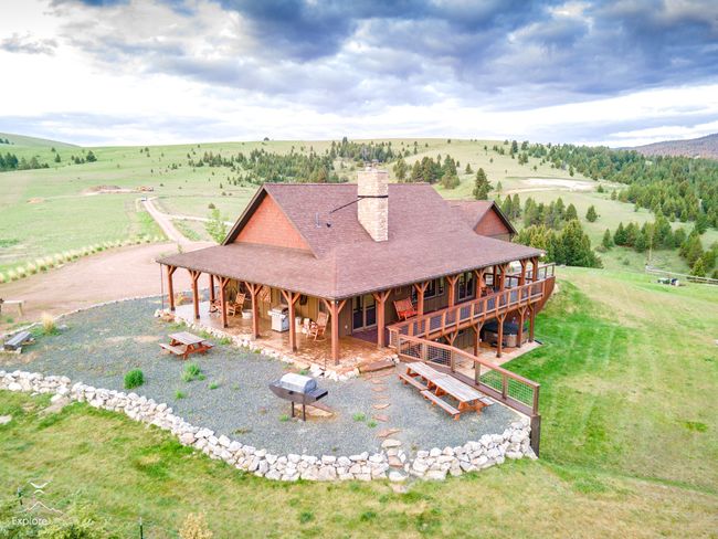 Rear view of house with a view of countryside, a chimney, a shingled roof, and a patio | Image 30