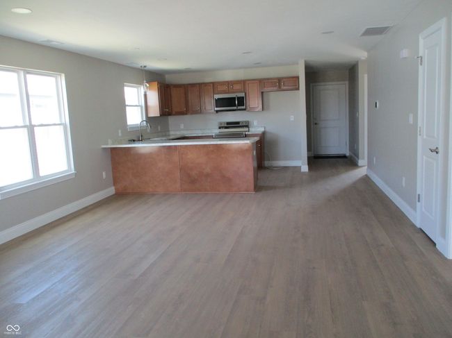 kitchen featuring visible vents, brown cabinets, a sink, appliances with stainless steel finishes, and a peninsula | Image 4