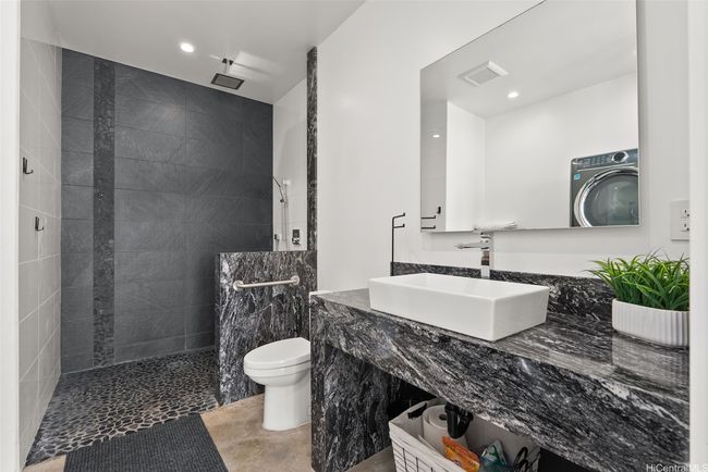 Lower level full bathroom with laundry, beautiful stone features. | Image 18