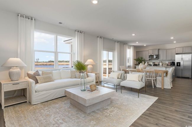 Living room with recessed lighting, visible vents, wood finished floors, and a water view | Image 9