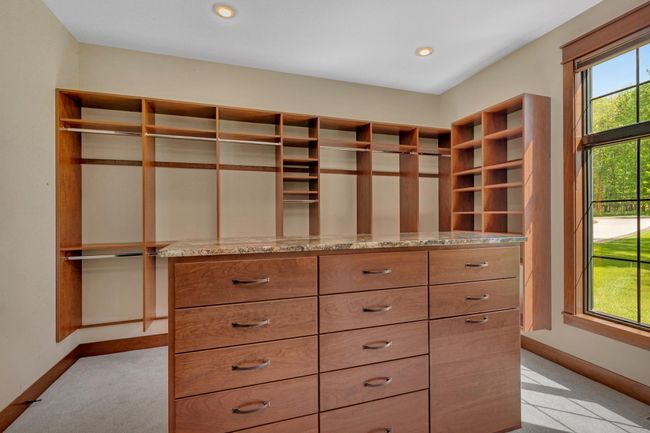 Walk-in closet featuring a central island with built-in drawers, providing stylish storage and easy organization. | Image 57