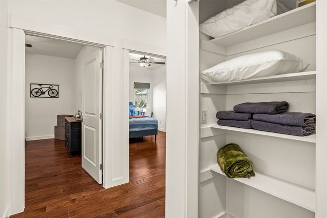 Walk in closet with dark wood-style flooring and ceiling fan | Image 20