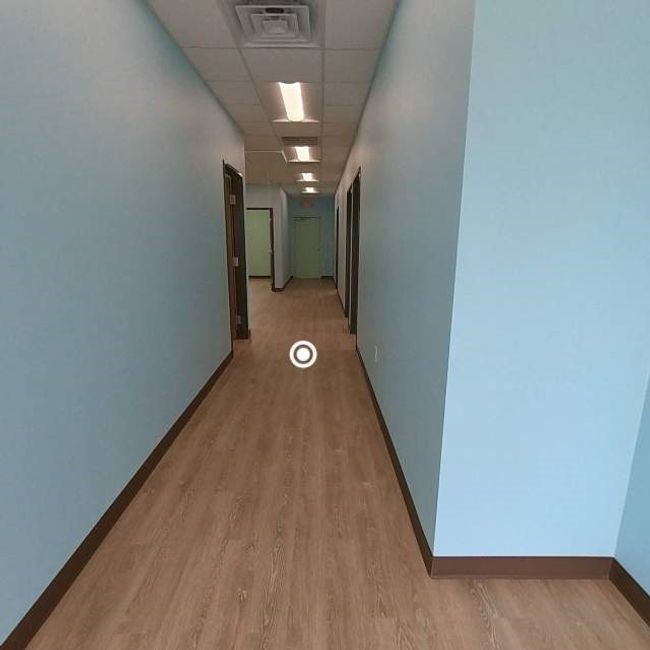 Corridor with a drop ceiling, baseboards, and light wood-style floors | Image 8