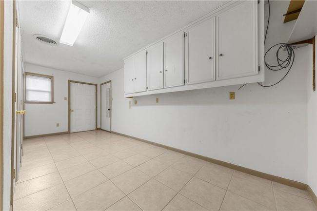 Empty room featuring a textured ceiling and light tile patterned flooring | Image 10
