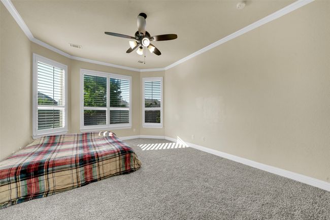 Bedroom with ornamental molding, carpet floors, and ceiling fan | Image 21