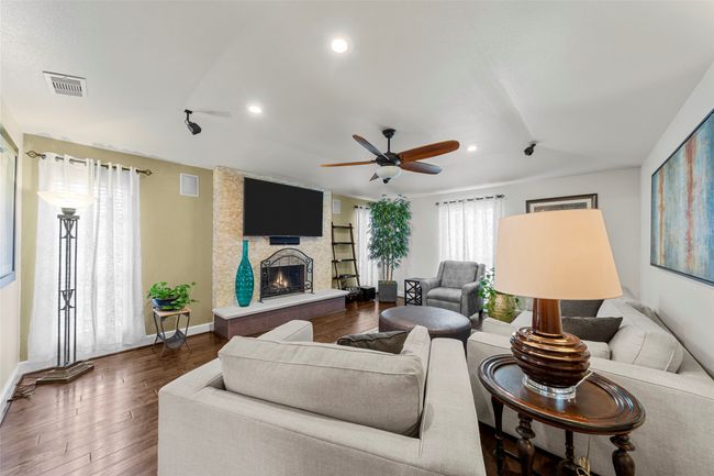 Living room with recessed lighting, a fireplace, a ceiling fan, visible vents, and dark wood finished floors | Image 13