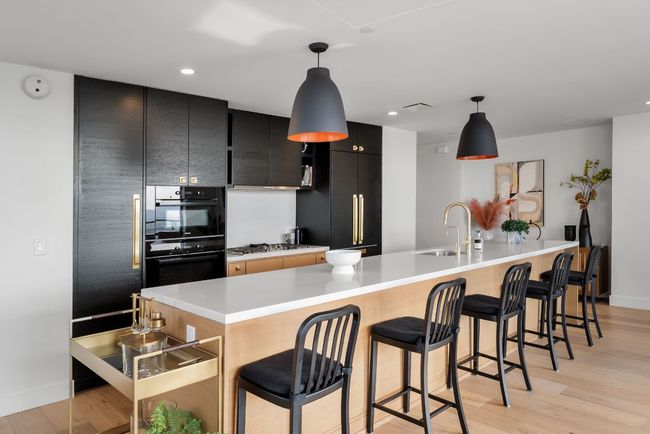 Stunning open kitchen featuring built-in Miele appliances, a gas cooktop, wine fridge, all overlooking the downtown views. | Image 12