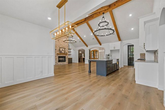 Kitchen featuring a fireplace, light hardwood / wood-style flooring, pendant lighting, and a kitchen island with sink | Image 10