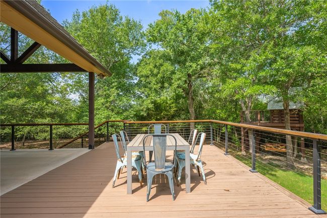 Deck with outdoor dining space and view of scattered trees | Image 29