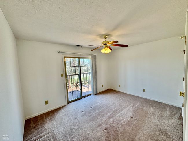 carpeted empty room featuring a ceiling fan, baseboards, and a textured ceiling | Image 8