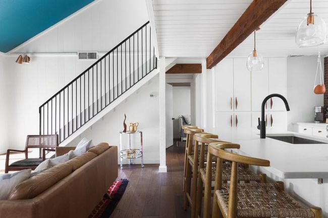 Living room featuring dark wood-style flooring, beam ceiling, stairway, and visible vents | Image 4
