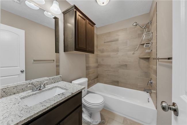 Full bathroom featuring toilet, tiled shower / bath, a textured ceiling, vanity, and tile patterned flooring | Image 20