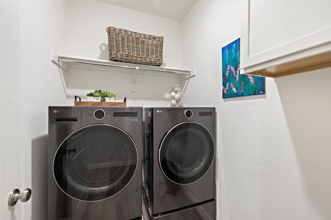 Spacious laundry room with built-in cabinetry and open shelving for convenient storage and organization. | Image 28