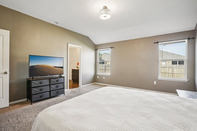 Carpeted bedroom featuring lofted ceiling and ensuite bath | Image 19