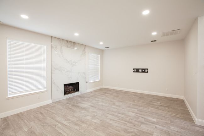 Unfurnished living room featuring recessed lighting, light wood finished floors, and a high end fireplace | Image 21