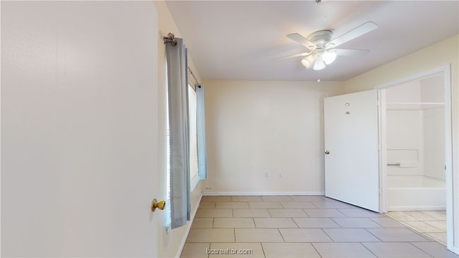 Unfurnished bedroom featuring multiple windows, light tile patterned floors, and ceiling fan | Image 17