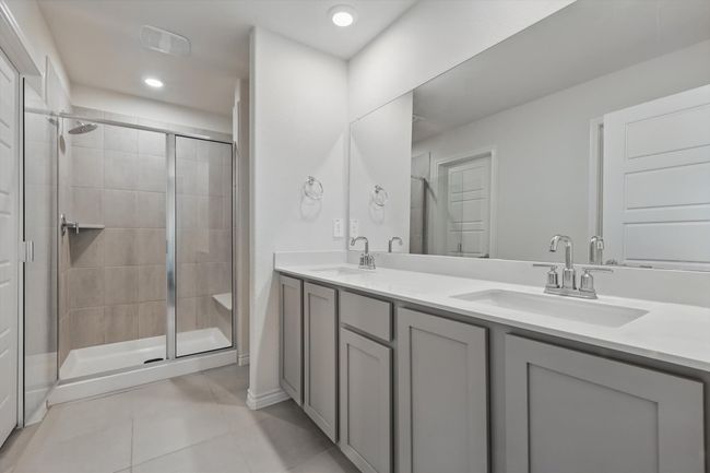 Full bathroom featuring tile patterned floors, a shower stall, double vanity, and recessed lighting | Image 22
