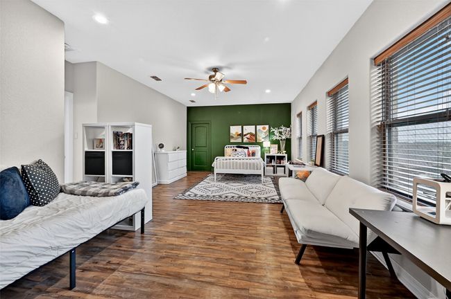 Bedroom featuring wood finished floors, recessed lighting, and lofted ceiling | Image 28