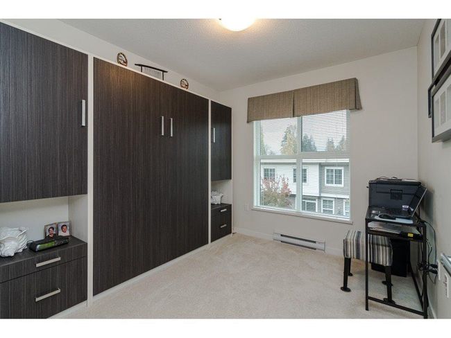 Office space with a baseboard heating unit, baseboards, and light colored carpet | Image 13