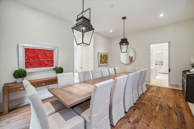 Spacious formal dining room with walnut flooring and high ceilings. | Image 11