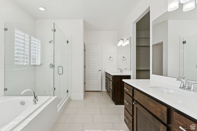 Bathroom with a stall shower, two vanities, tile patterned flooring, a bath, and recessed lighting | Image 15