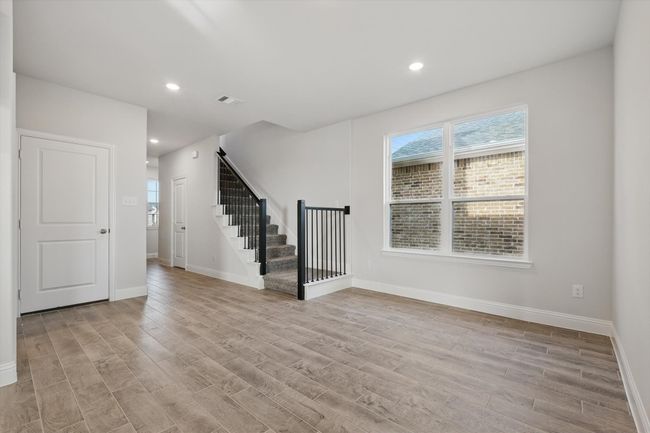living room with stairs, recessed lighting, and light tile that looks like wood flooring | Image 7