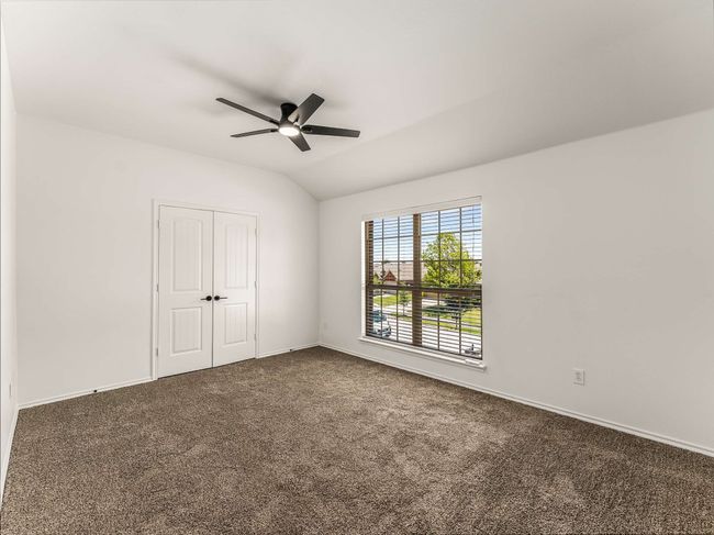 Unfurnished bedroom with dark colored carpet, a closet, vaulted ceiling, and ceiling fan | Image 28