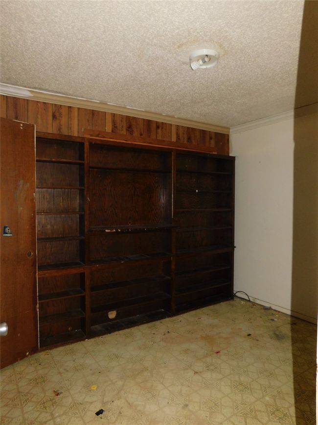 Basement with crown molding and a textured ceiling | Image 13