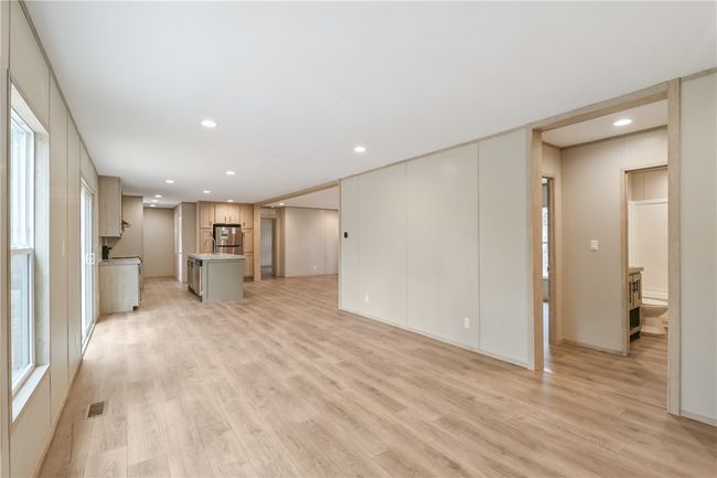 Unfurnished living room featuring light wood-style floors, recessed lighting, visible vents, and baseboards | Image 11