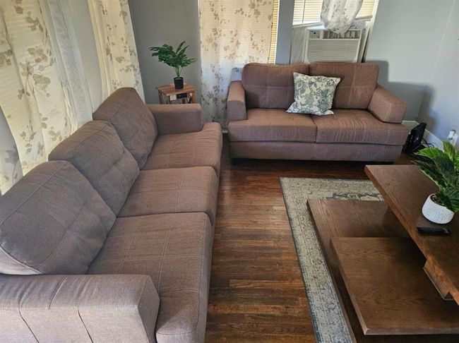 Cozy living room in a charming two-bedroom unit, featuring stylish decor and inviting natural light. | Image 9
