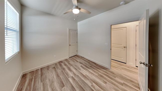 Unfurnished bedroom with baseboards, multiple windows, and light wood finished floors | Image 15