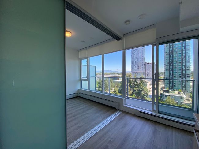Unfurnished room with wood finished floors, baseboard heating, and a view of city | Image 8