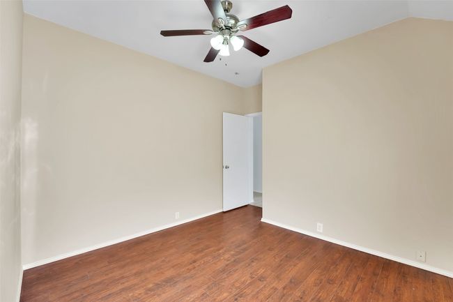 Unfurnished room featuring wood-type flooring, ceiling fan, and lofted ceiling | Image 20
