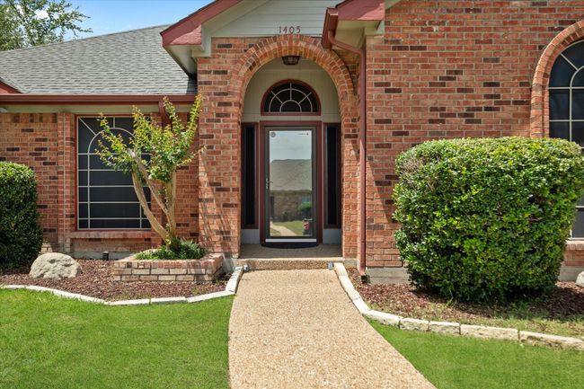 Entrance to property with brick siding and roof with shingles | Image 5