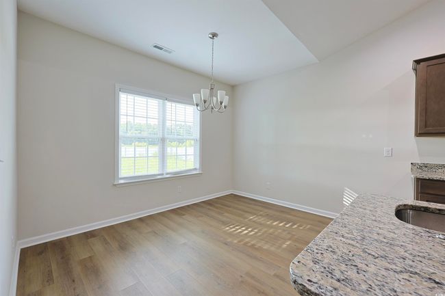 Unfurnished dining area with wood finished floors and a chandelier | Image 9