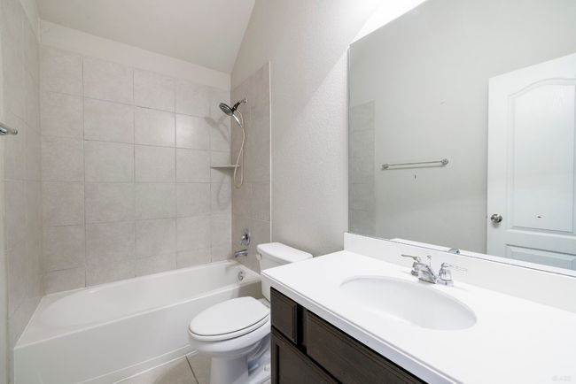 Full bath featuring vanity, tub / shower combination, and lofted ceiling | Image 23
