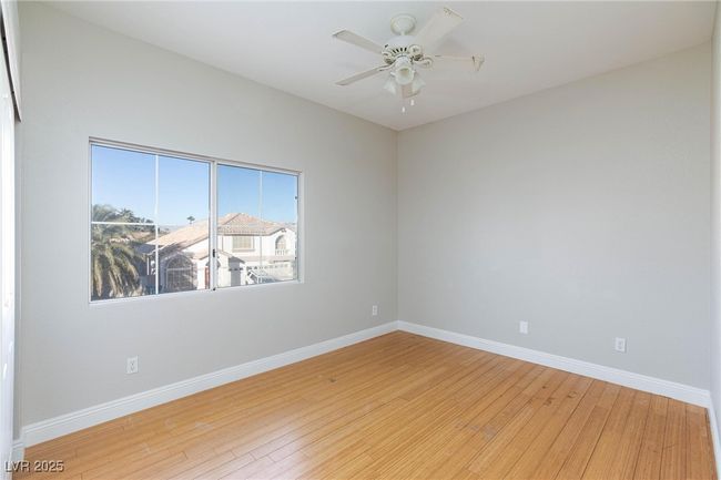 Unfurnished room with wood-type flooring, baseboards, and a ceiling fan | Image 36